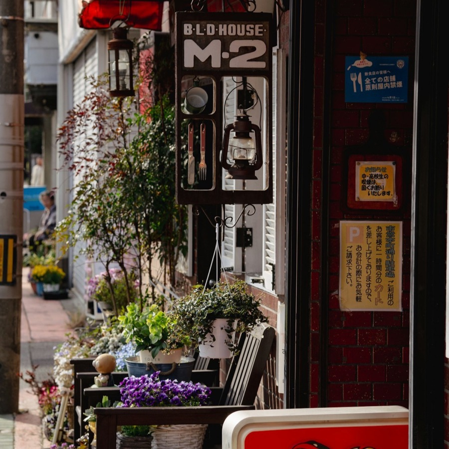 植物とコーヒーの看板が並ぶ趣のある店先